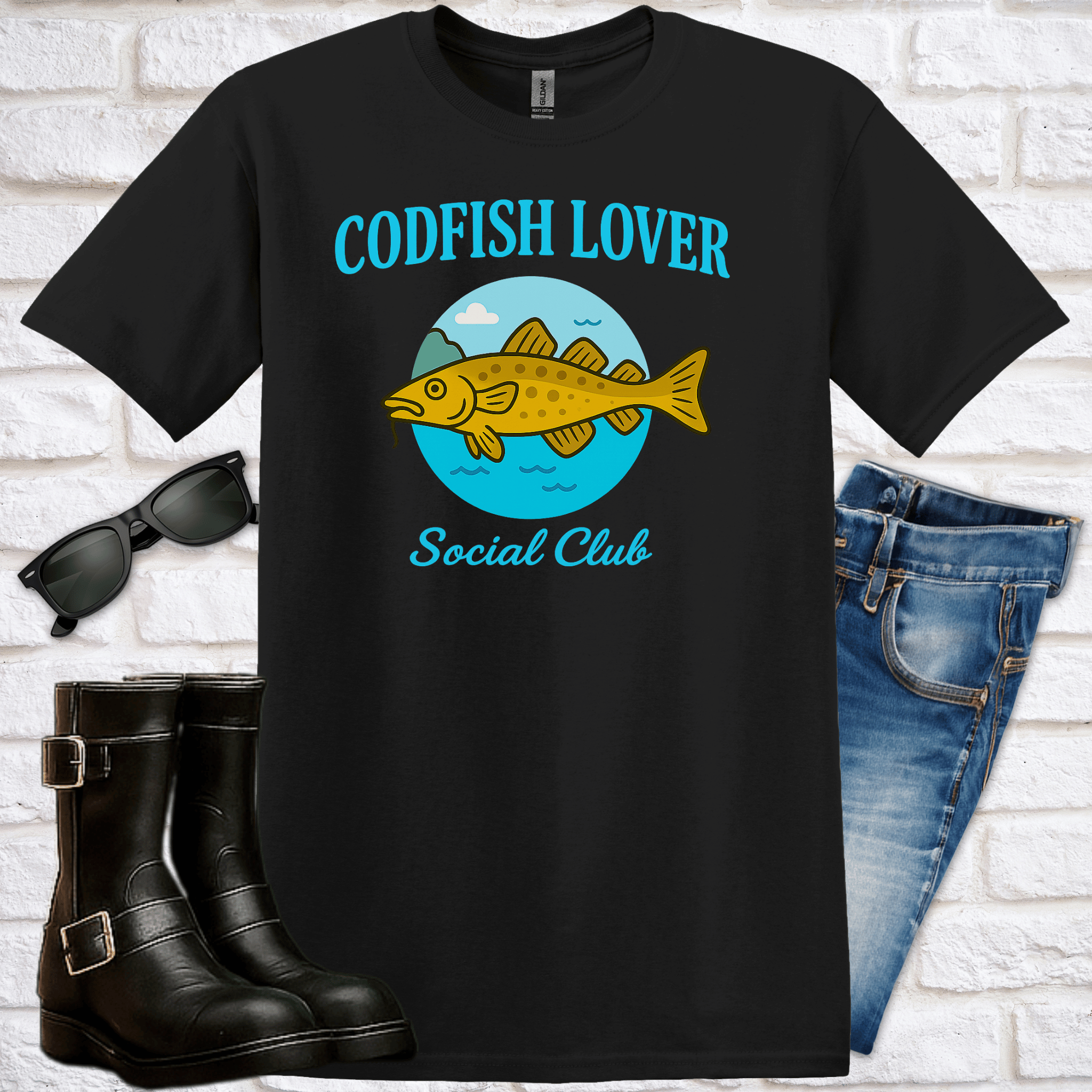 Black t-shirt with 'Codfish Lover Social Club' design, sunglasses, boots, and jeans on a white brick background
