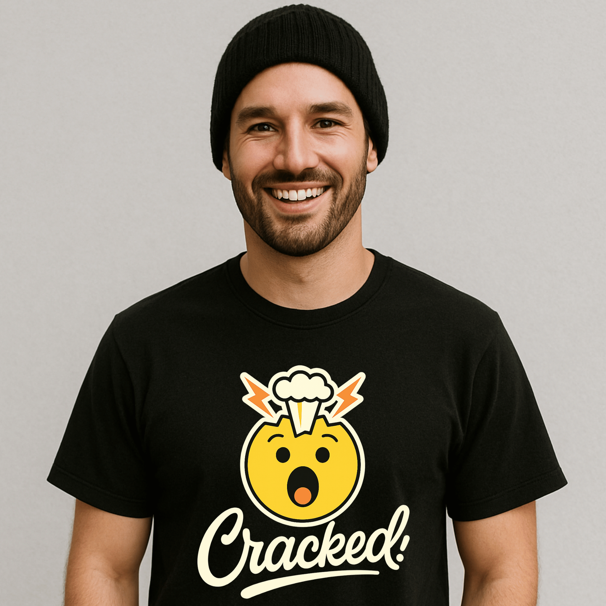 Man wearing a black t-shirt with a yellow emoji with a funny brain explosion and 'Cracked!' text on a white/gray background