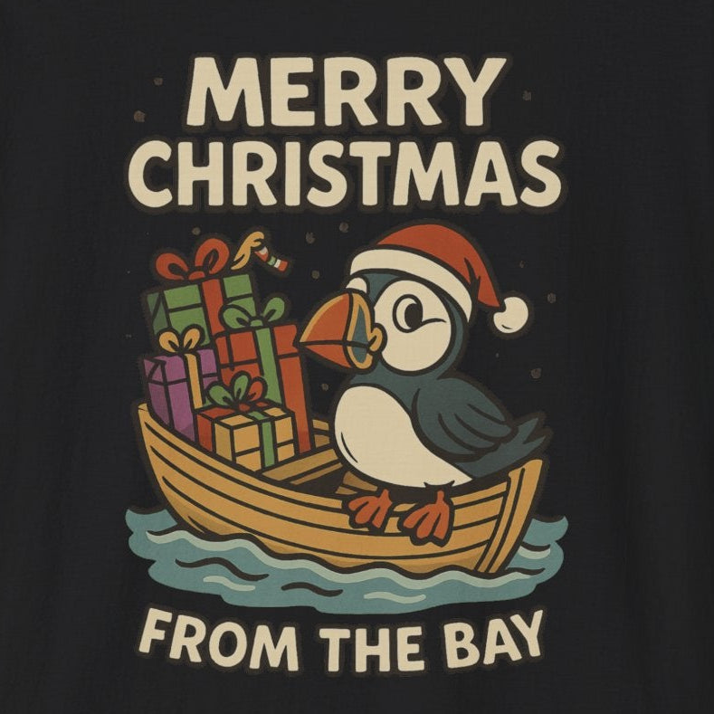 Black shirt with a puffin in a dory full of presents. It says "Merry Christmas from the Bay."
