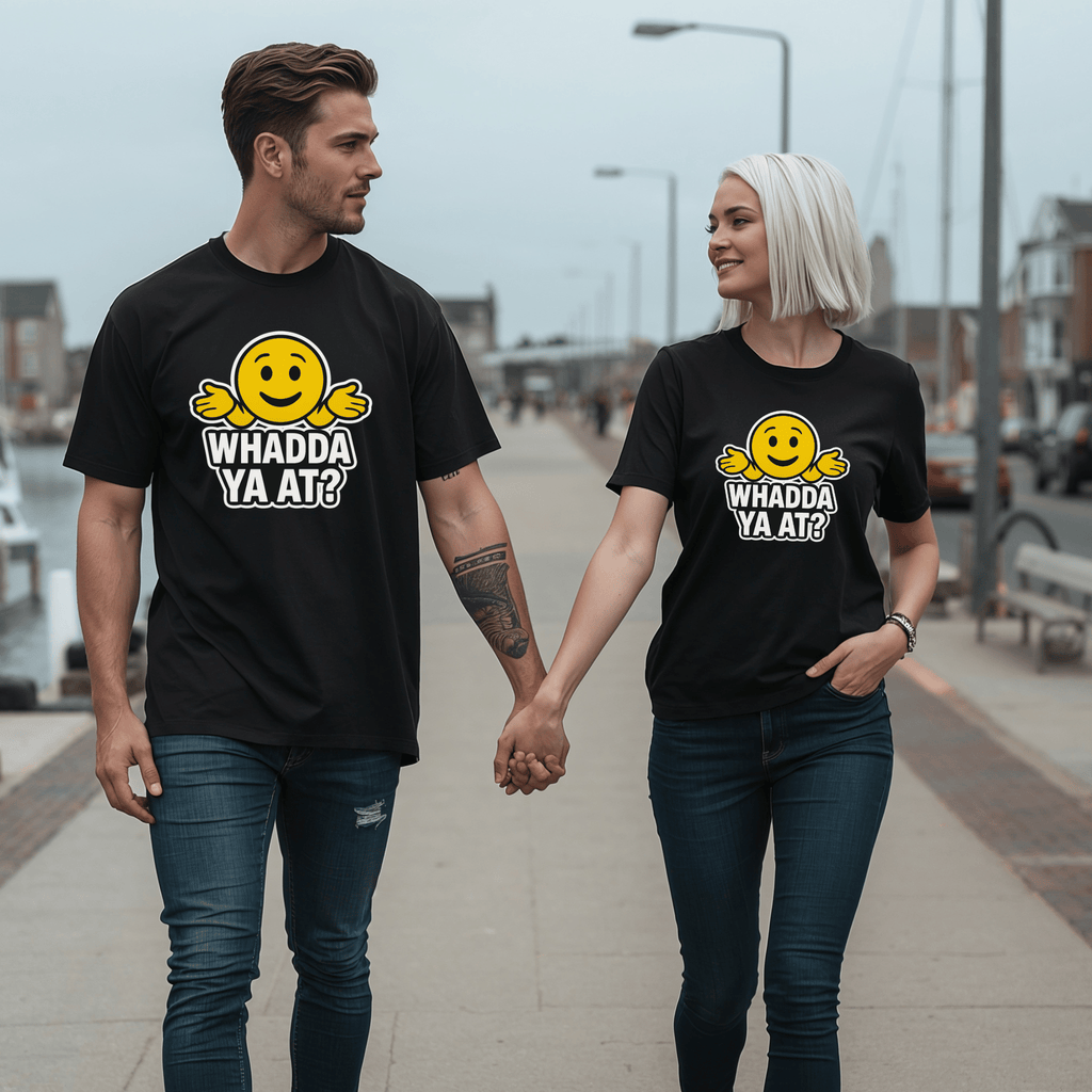 An attractive couple walking hand in hand wearing t-shirts with emojis and text saying "whadda ya at?"