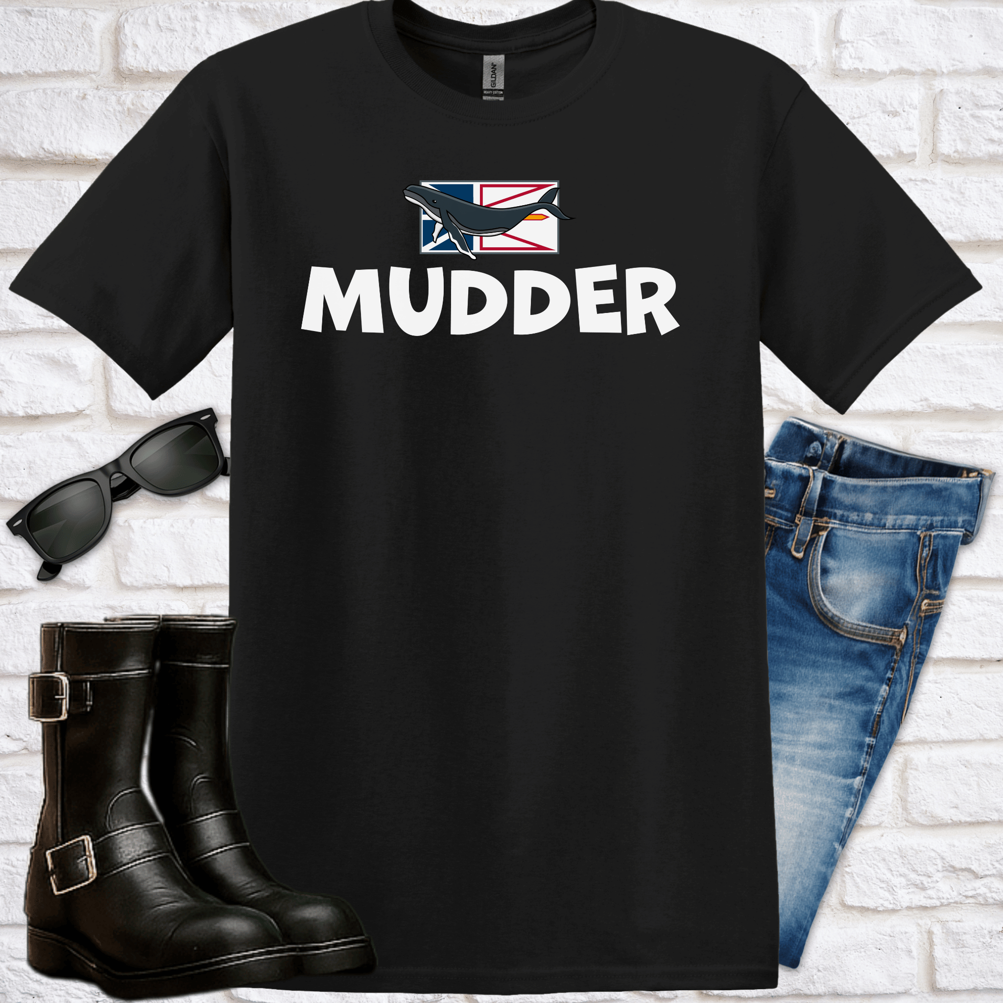Black t-shirt with 'Mudder' text and flag design, paired with boots, sunglasses, and jeans on a white brick background.