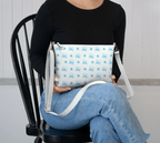 Woman holding our Starfish Shores Crossbody Purse featuring a soft blue pattern of starfish and Newfoundland outlines in flowing script.
