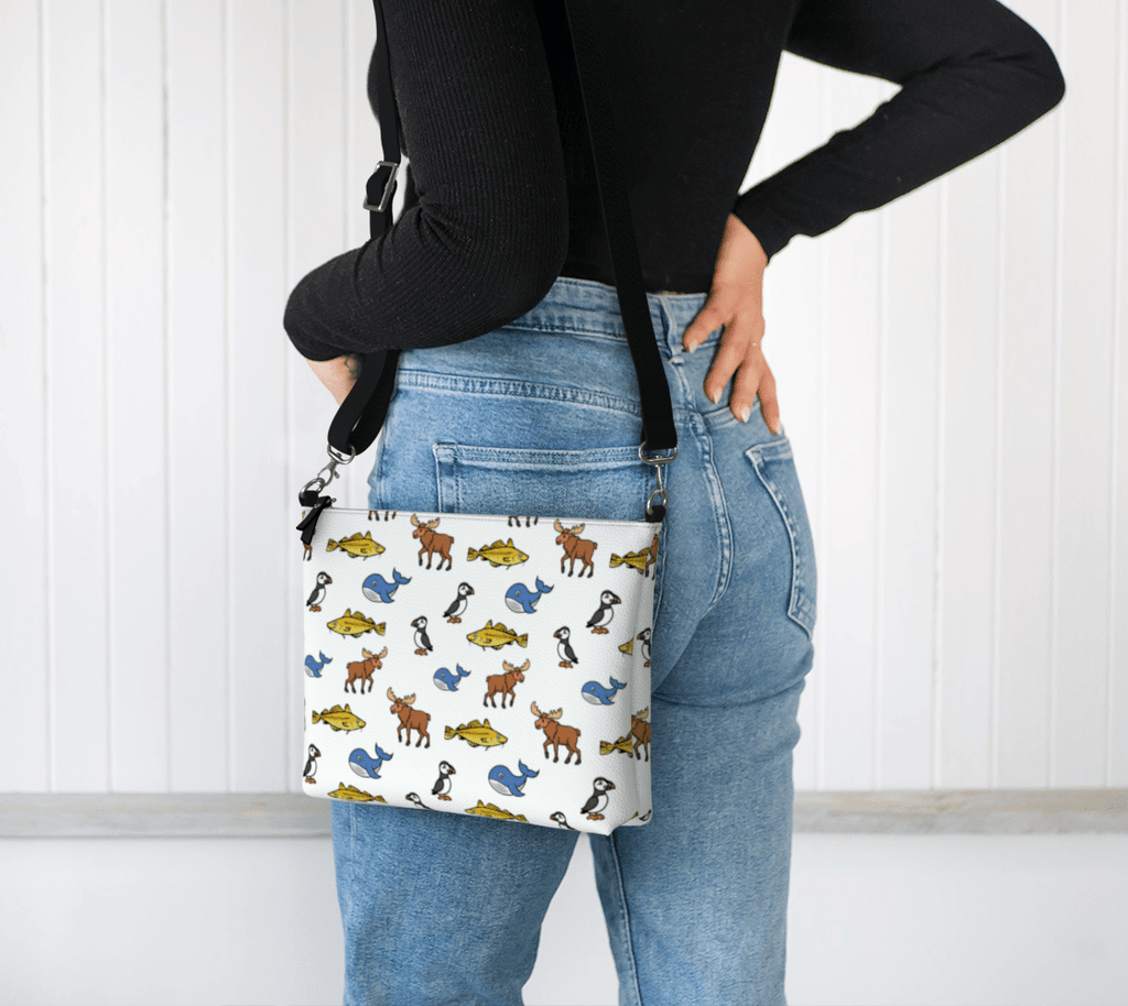 Person wearing a colorful Newfoundland and Labrador animal patterned bag on her hip against a white background