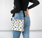 Person wearing a colorful Newfoundland and Labrador animal patterned bag on her hip against a white background