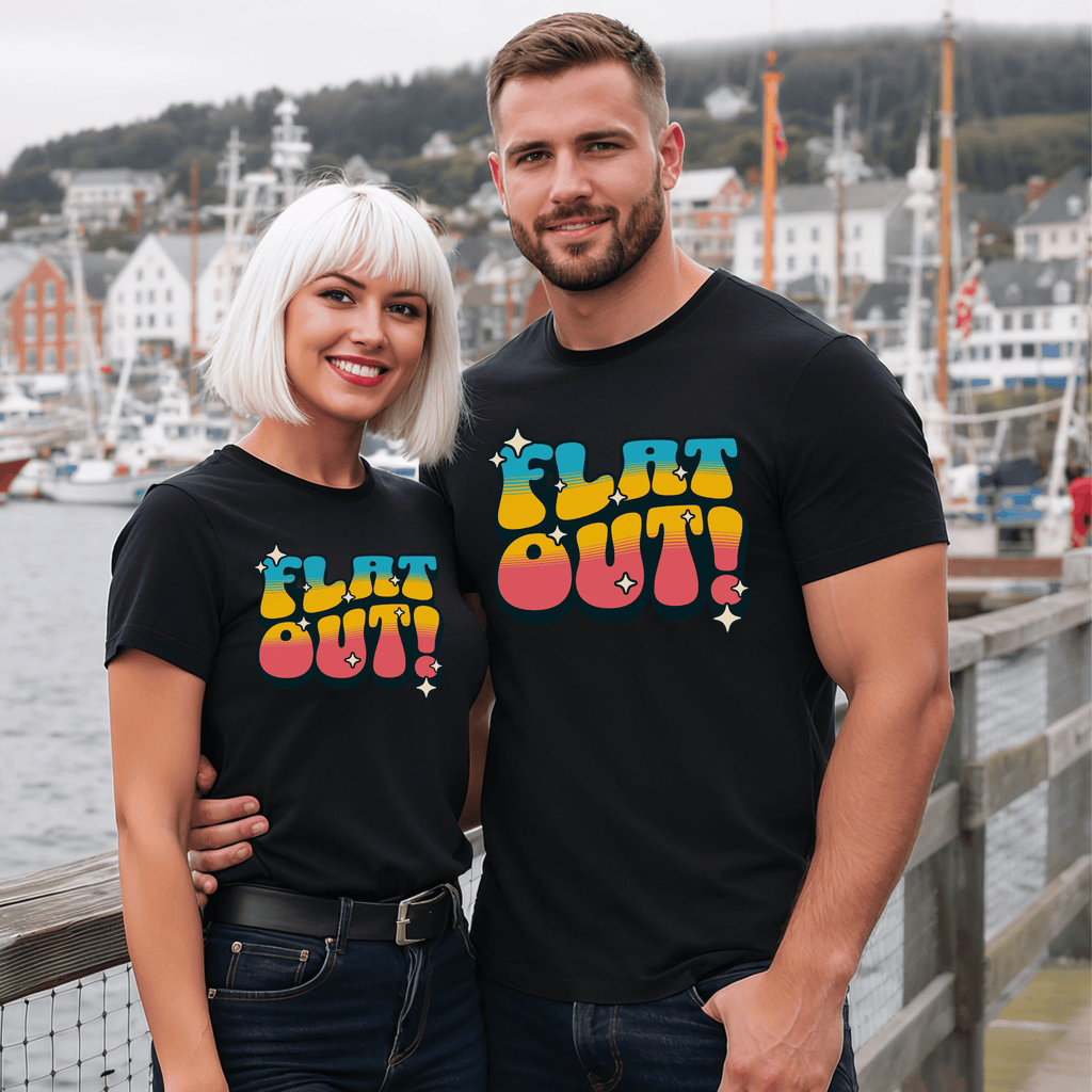 Two attractive people wearing black t-shirts with a retro-style 'FLAT OUT!' design by a waterfront.
