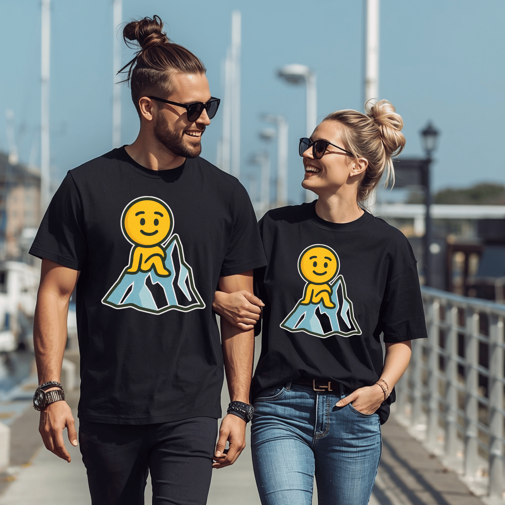Two attractive people wearing black t-shirts with a smiley face emoji sitting on an iceberg, and walking together outdoors.