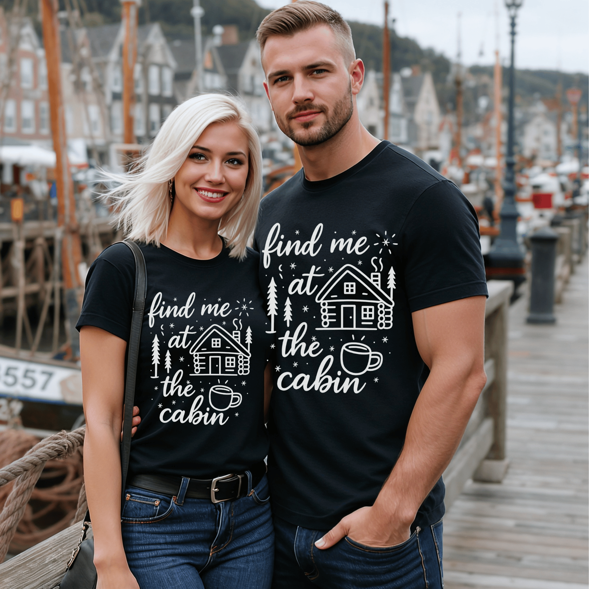 Attractive couple wearing matching black t-shirts with a cabin-themed design with the words "find me at the cabin."