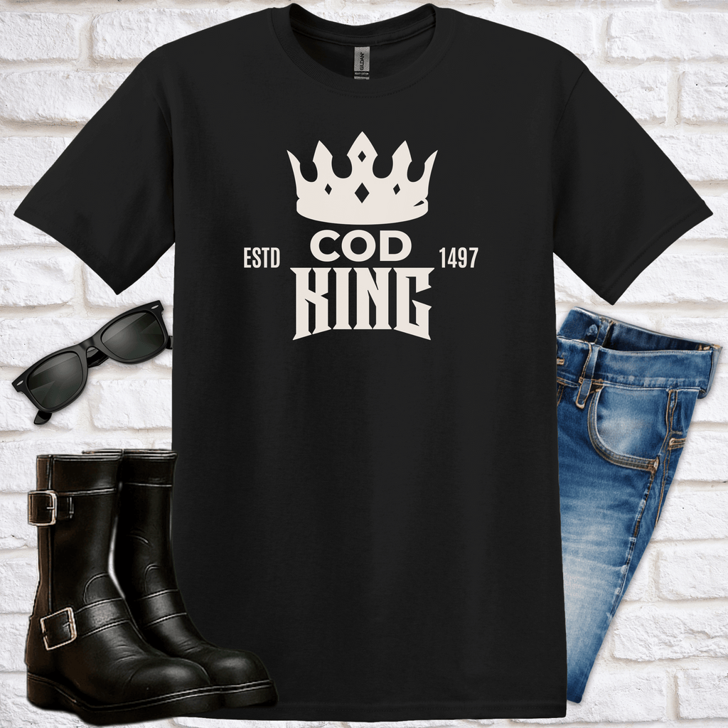 Black t-shirt with 'COD KING' design, sunglasses, boots, and jeans on a white brick background