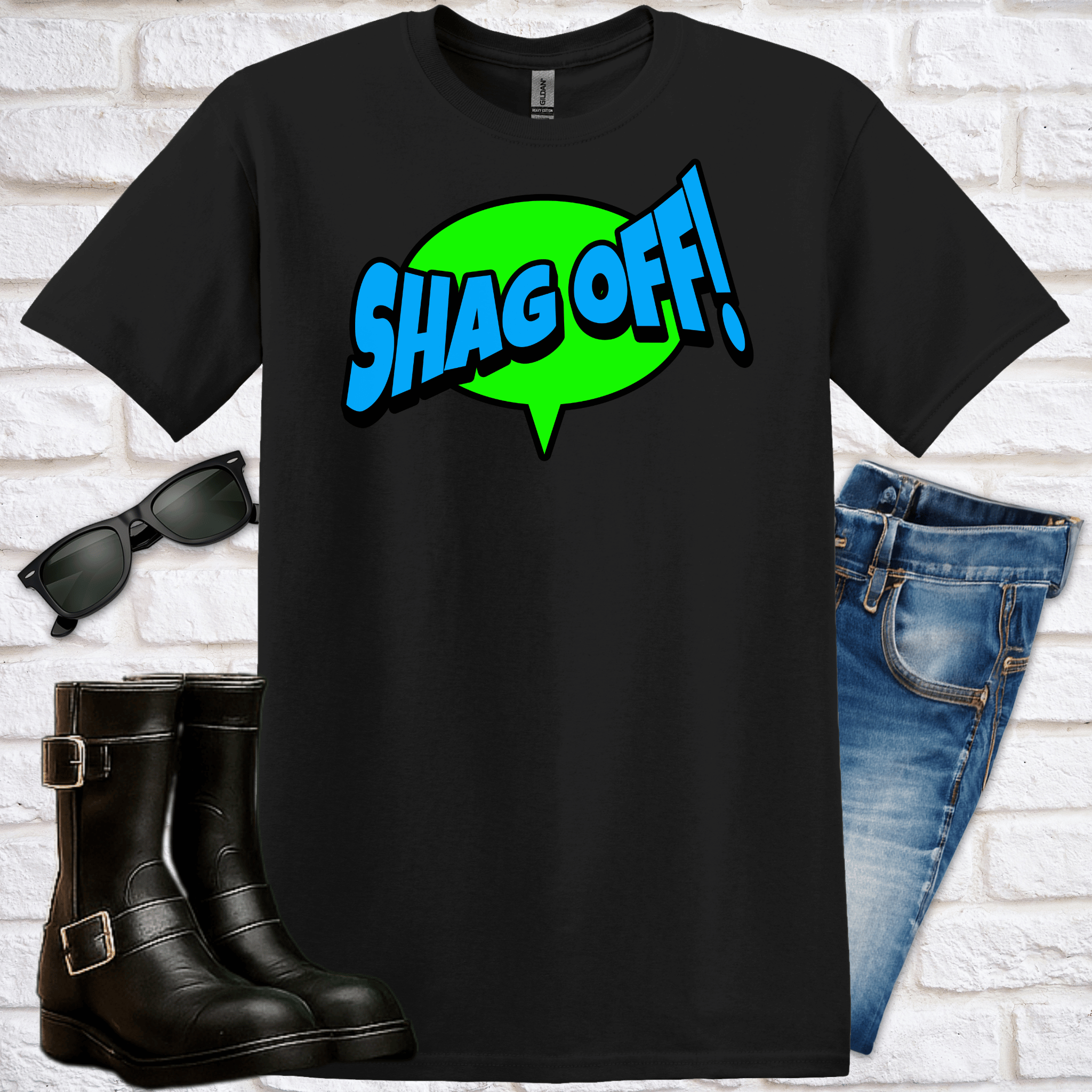 Black t-shirt with 'SHAG OFF!' text, sunglasses, boots, and jeans on a white brick wall background