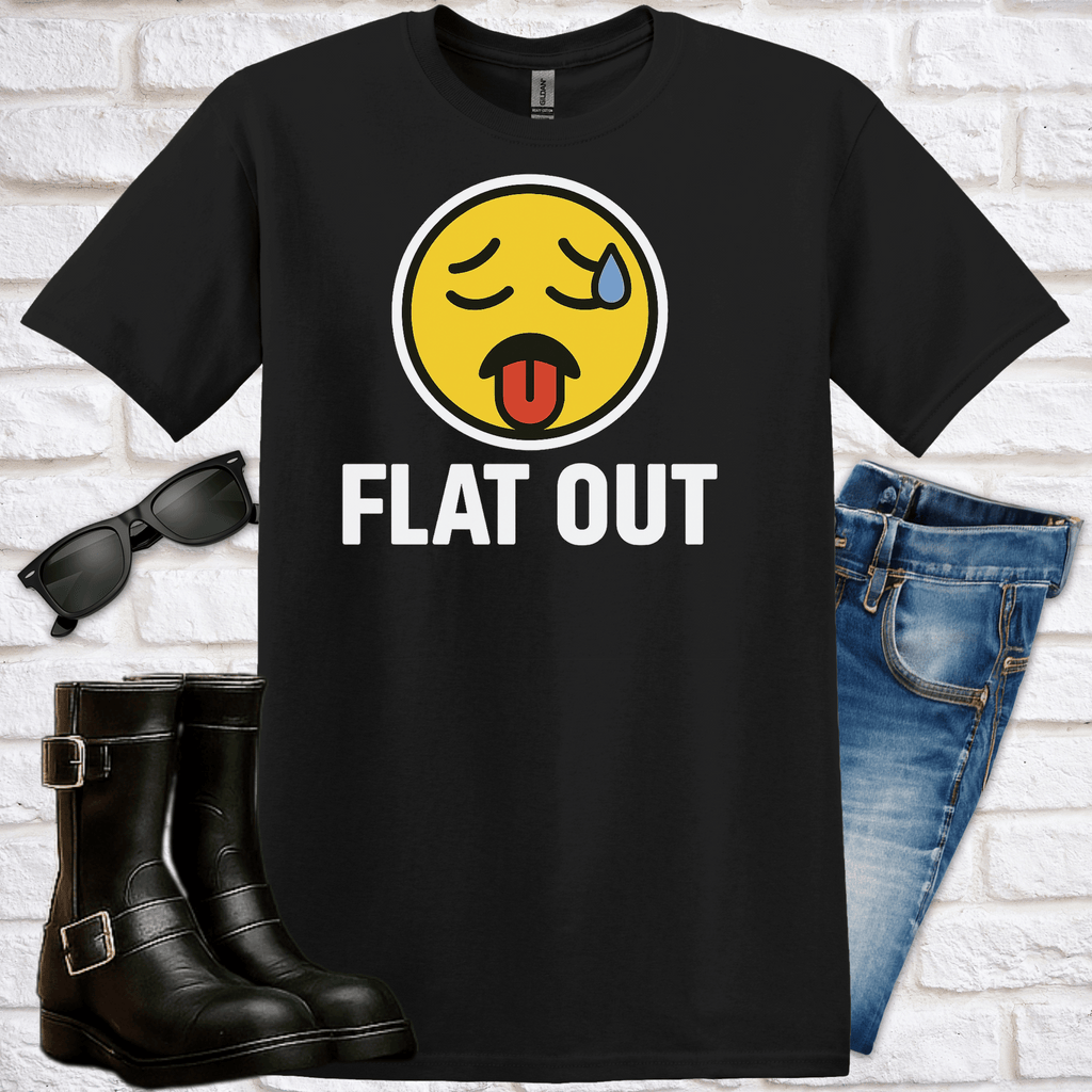 Black t-shirt with a yellow emoji and 'FLAT OUT' text, sunglasses, boots, and jeans on a white brick background