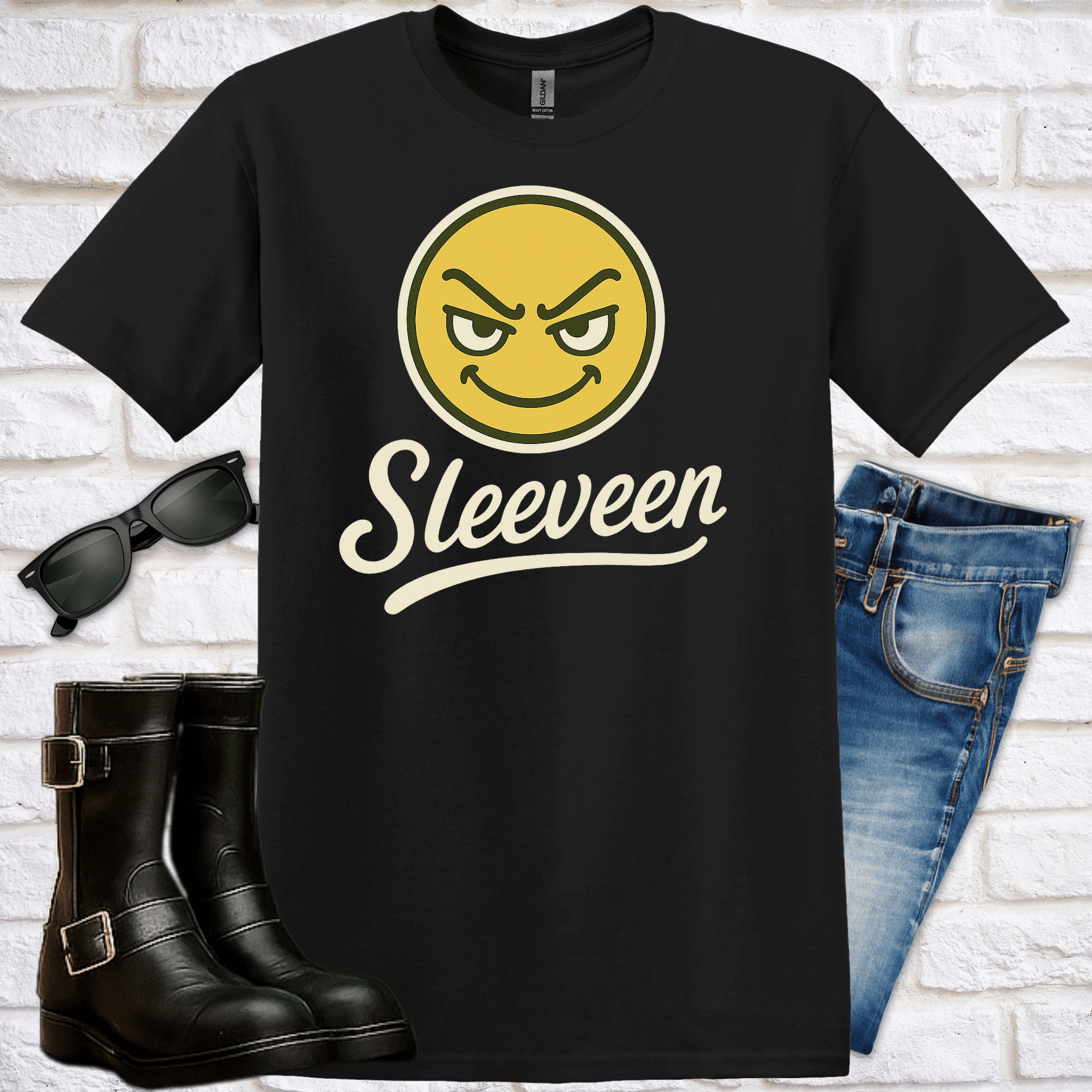 Black t-shirt with fun-loving yellow smiley face emoji and 'Sleeven' text, paired with sunglasses, boots, and jeans on a white brick background.