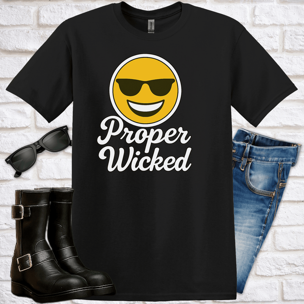 Black t-shirt with a smiley face emoji wearing sunglasses and 'Proper Wicked' text, sunglasses, boots, and jeans on a white brick background.