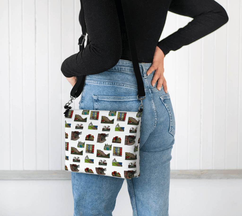 Person wearing a crossbody bag with a pattern of the landmarks of St. John's, Newfoundland, on a white background