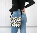 Person wearing a crossbody bag with a pattern of the landmarks of St. John's, Newfoundland, on a white background